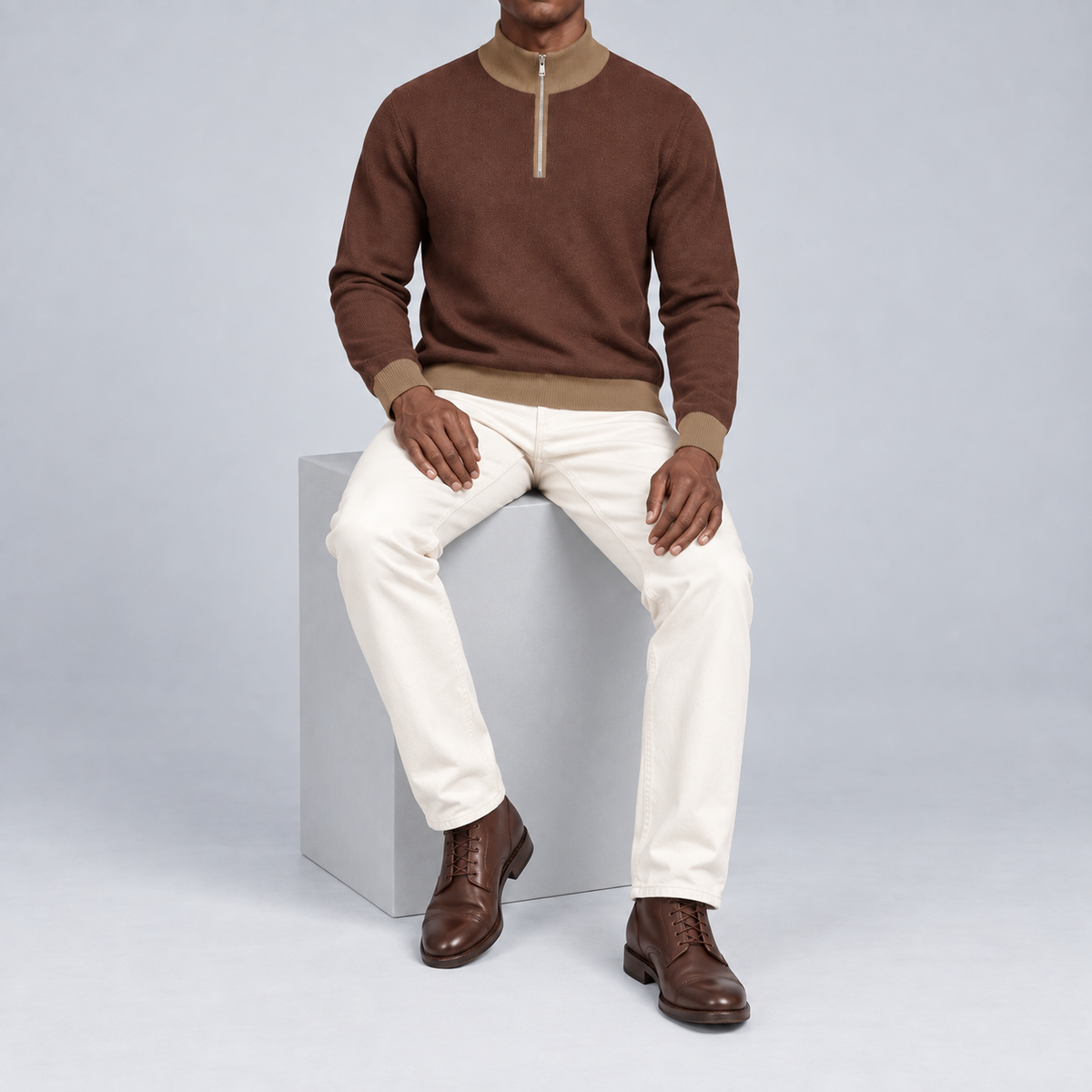 Seated studio view showing Soil knit drape and contrasting Peanut edges of Open Pace Quarter-Zip in Soil with Peanut Trim.