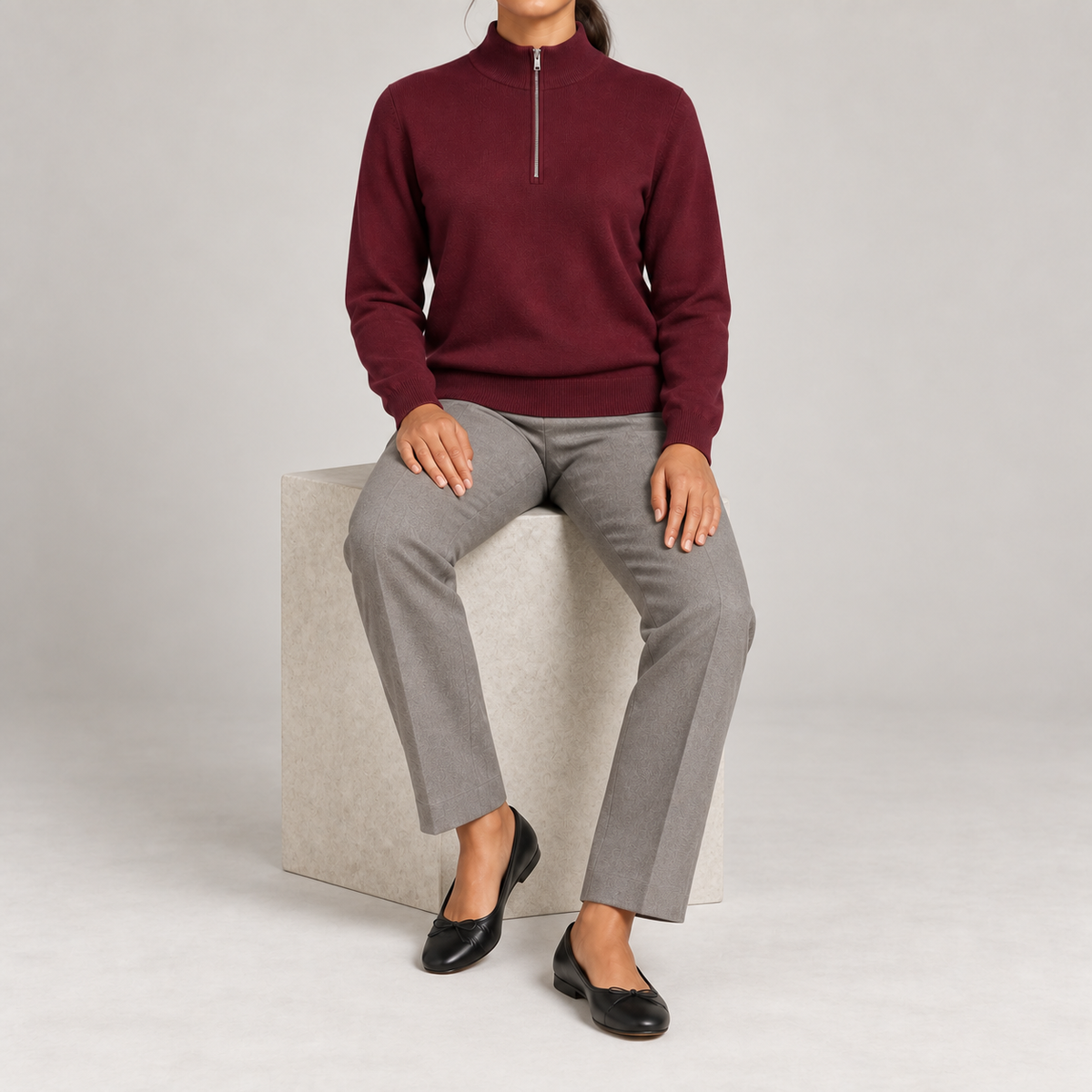 Seated studio view showing Burgundy knit drape and long sleeves of Soft Pace Quarter-Zip Sweater in Burgundy.