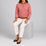 Seated studio view showing Coral knit drape and contrasting Rust edges of Soft Pace Quarter-Zip in Coral with Rust Trim.