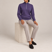 Seated studio view showing Violet knit drape and long sleeves of Soft Pace Quarter-Zip Sweater in Violet.
