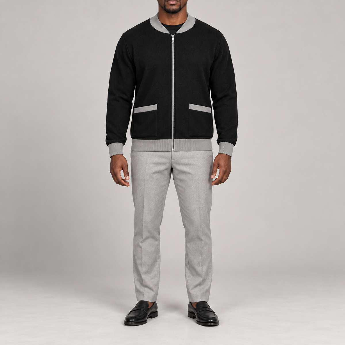 Front studio view showing full zip and grey-trimmed patch pockets of Afterlight Knit Bomber in Black with Grey Trim.