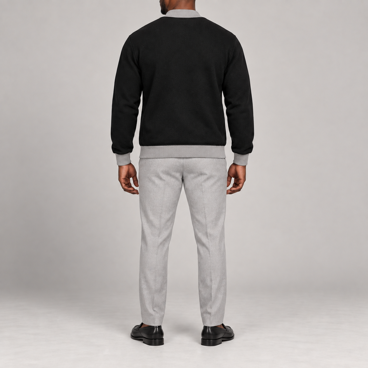 Rear studio view showing plain black knit and grey ribbed trim of Afterlight Knit Bomber in Black with Grey Trim.