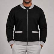 Close-up studio view showing grey collar, silver zipper and patch pockets of Afterlight Knit Bomber in Black with Grey Trim.