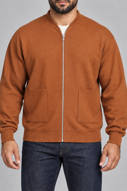 Close-up studio view showing low collar, zipper and fine knit texture of Afterlight Knit Bomber in Rust.