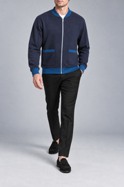 Walking studio view showing knit drape and contrasting trim of Afterlight Knit Bomber in Navy with Yale Blue Trim.