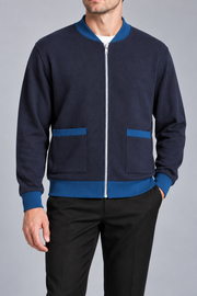Close-up studio view showing low collar, zipper and fine knit texture of Afterlight Knit Bomber in Navy with Yale Blue Trim.