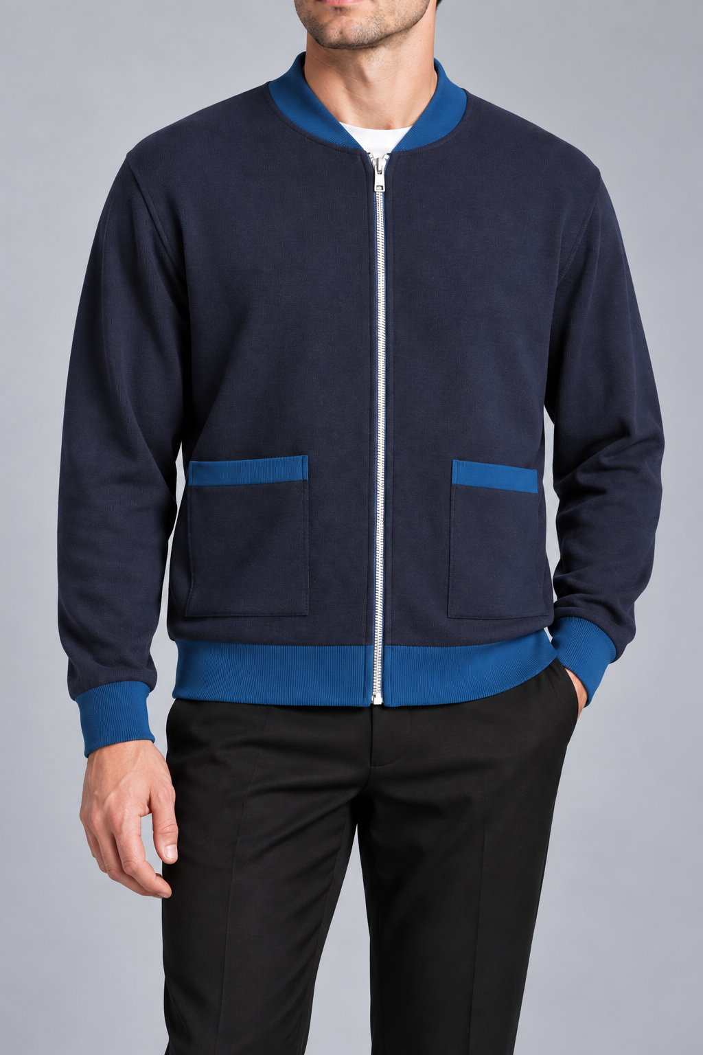 Close-up studio view showing low collar, zipper and fine knit texture of Afterlight Knit Bomber in Navy with Yale Blue Trim.