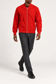 Walking studio view showing knit drape and front pockets of Afterlight Knit Bomber in Chili.