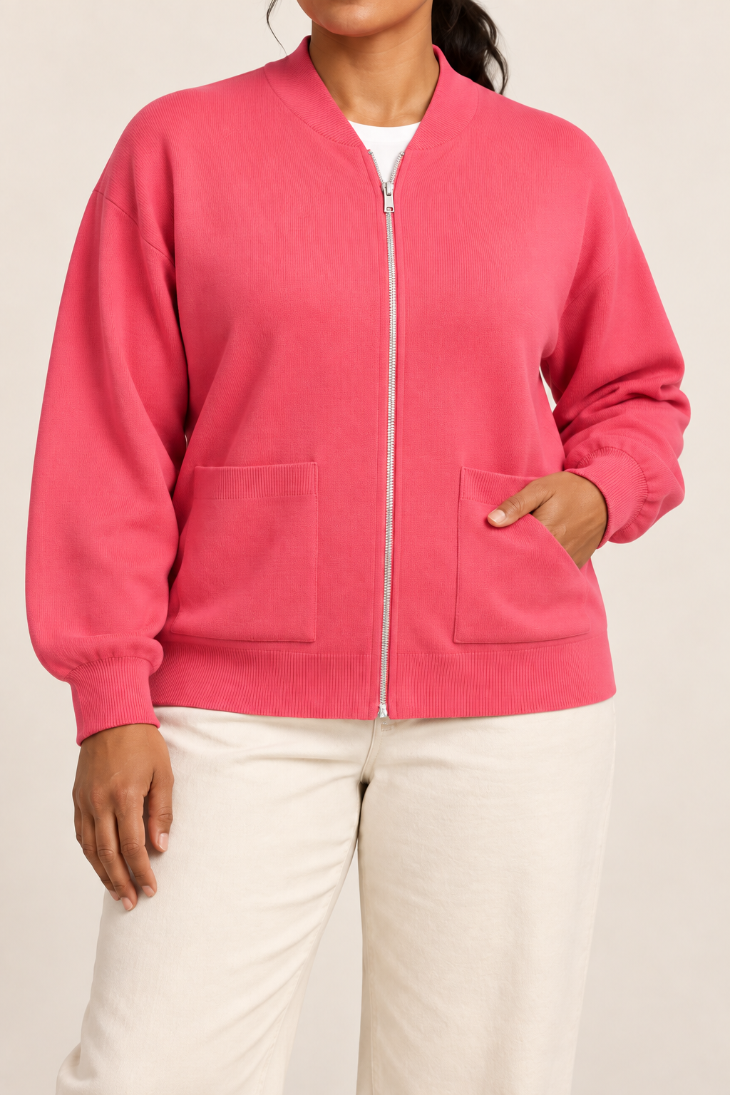 Close-up studio view showing low collar, zipper and fine knit texture of Soft Afterlight Knit Bomber in Hot Pink.