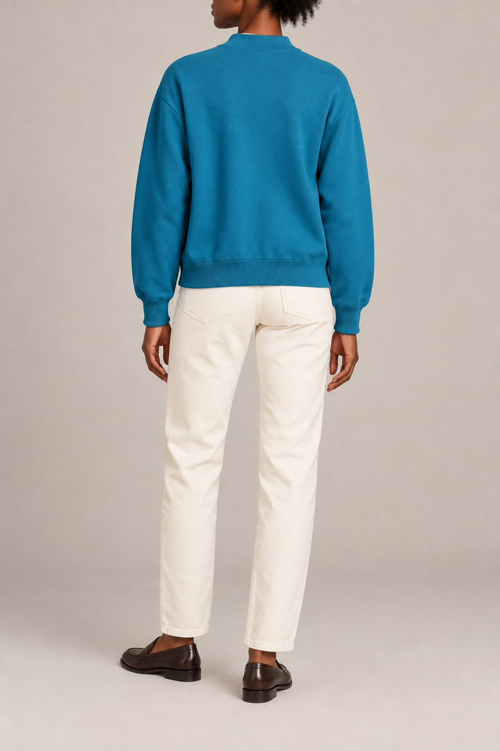 Rear studio view showing plain knit back and ribbed hem of Soft Afterlight Knit Bomber in Cyan.