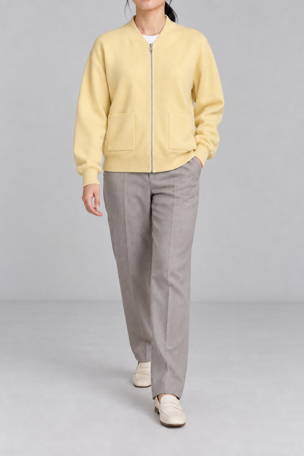 Walking studio view showing knit drape and front pockets of Soft Afterlight Knit Bomber in Mellow.