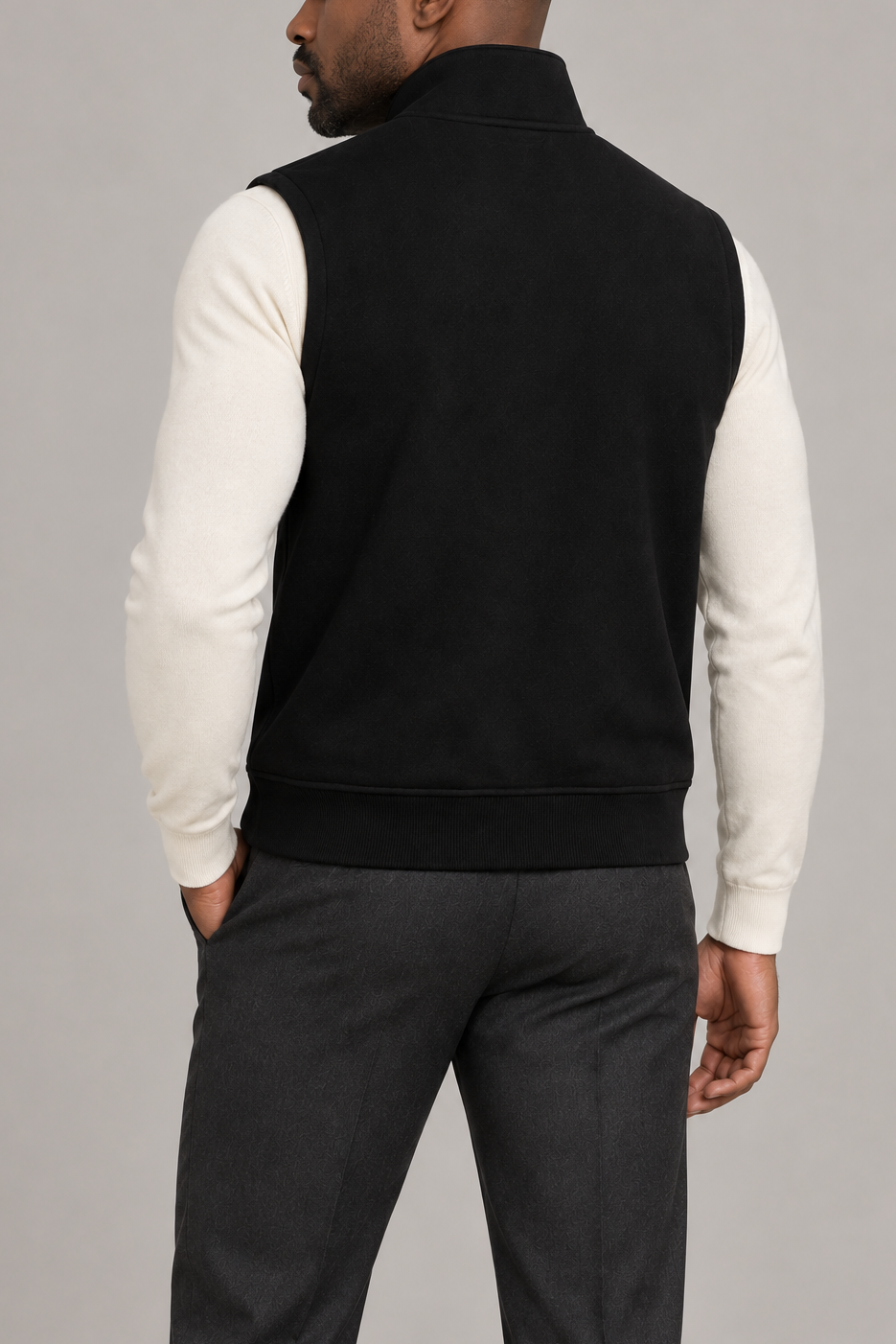 Still Form Zip Vest in Black, elegantly layered on a male model, rear three-quarter view.