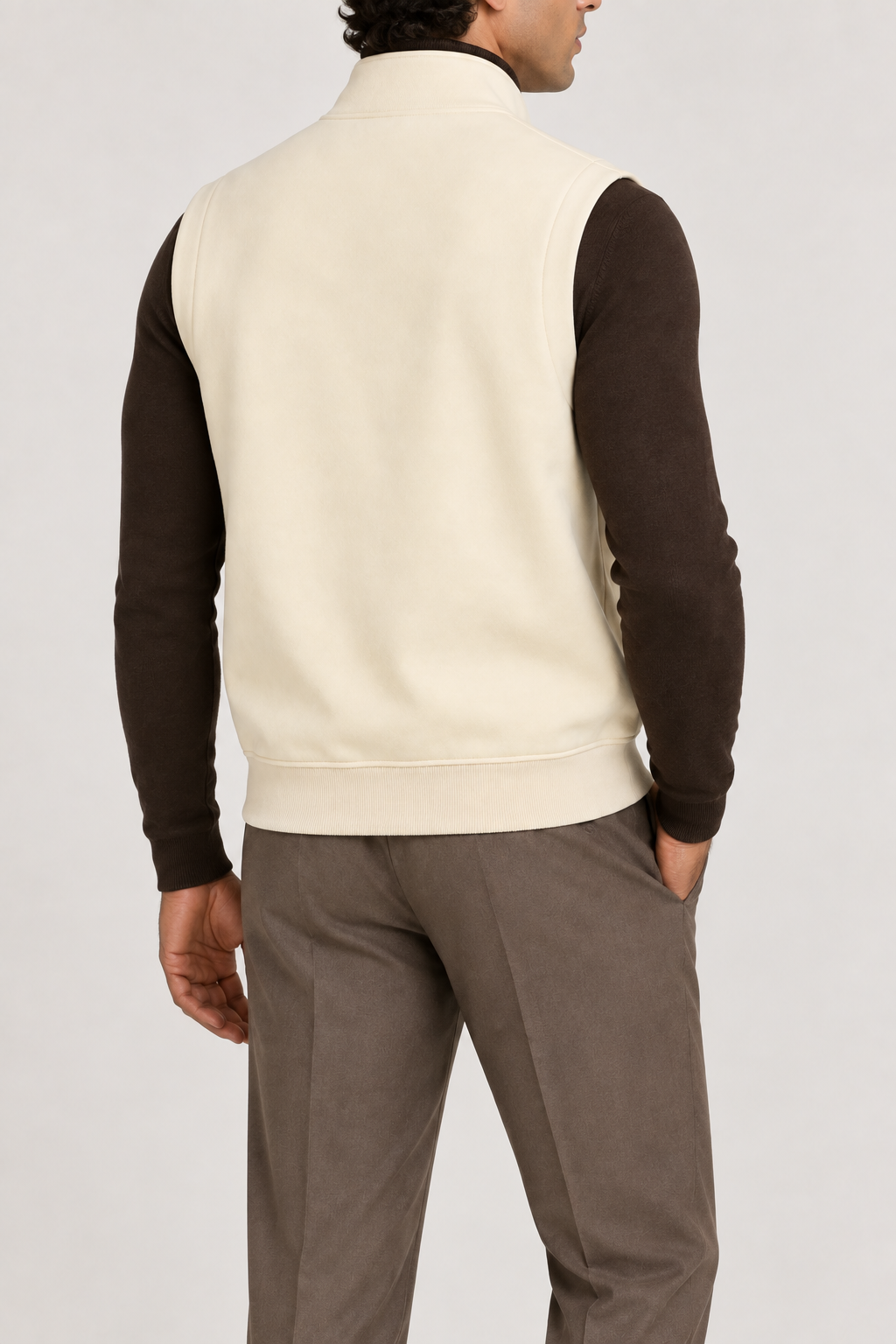 Still Form Zip Vest in Mild Apricot, elegantly layered on a male model, rear three-quarter view.