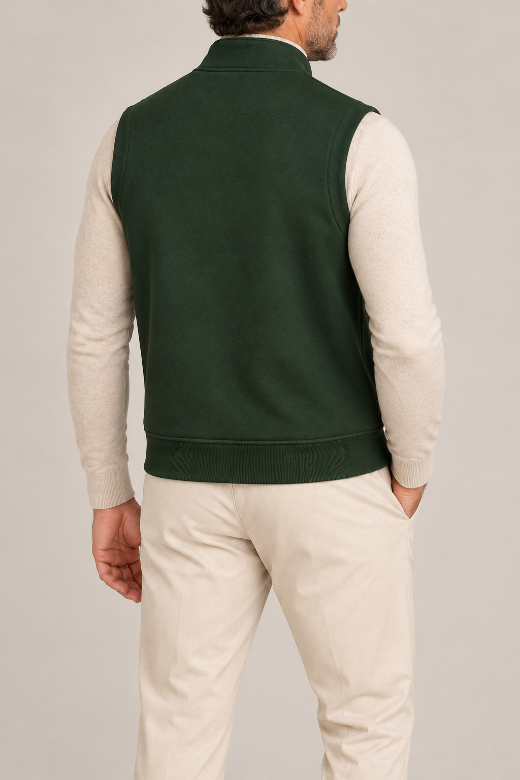 Still Form Zip Vest in Dark Green, elegantly layered on a male model, rear three-quarter view.