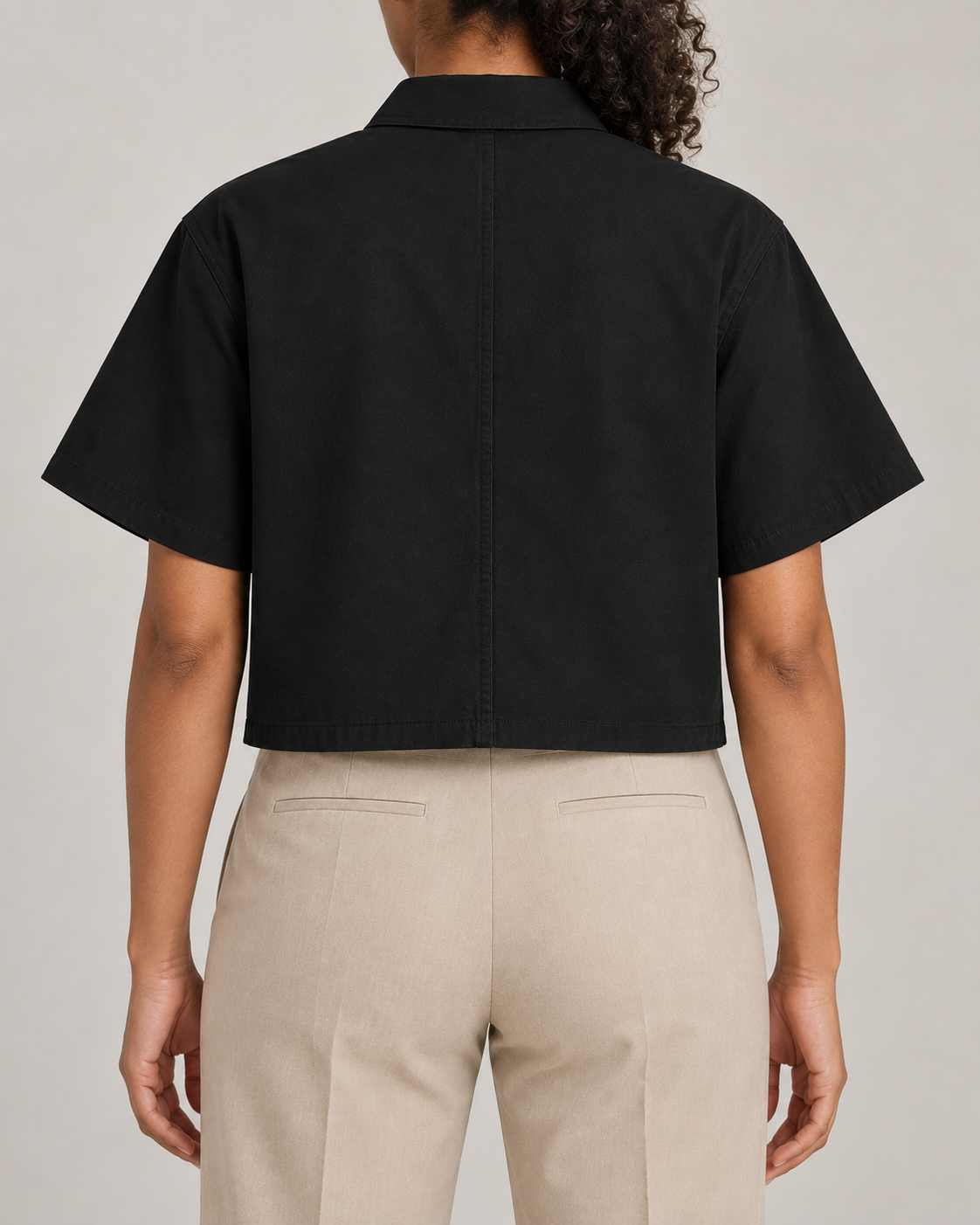 Rear view of Quiet Line Crop Shirt in Black, showing the plain back, centre seam and straight hem.