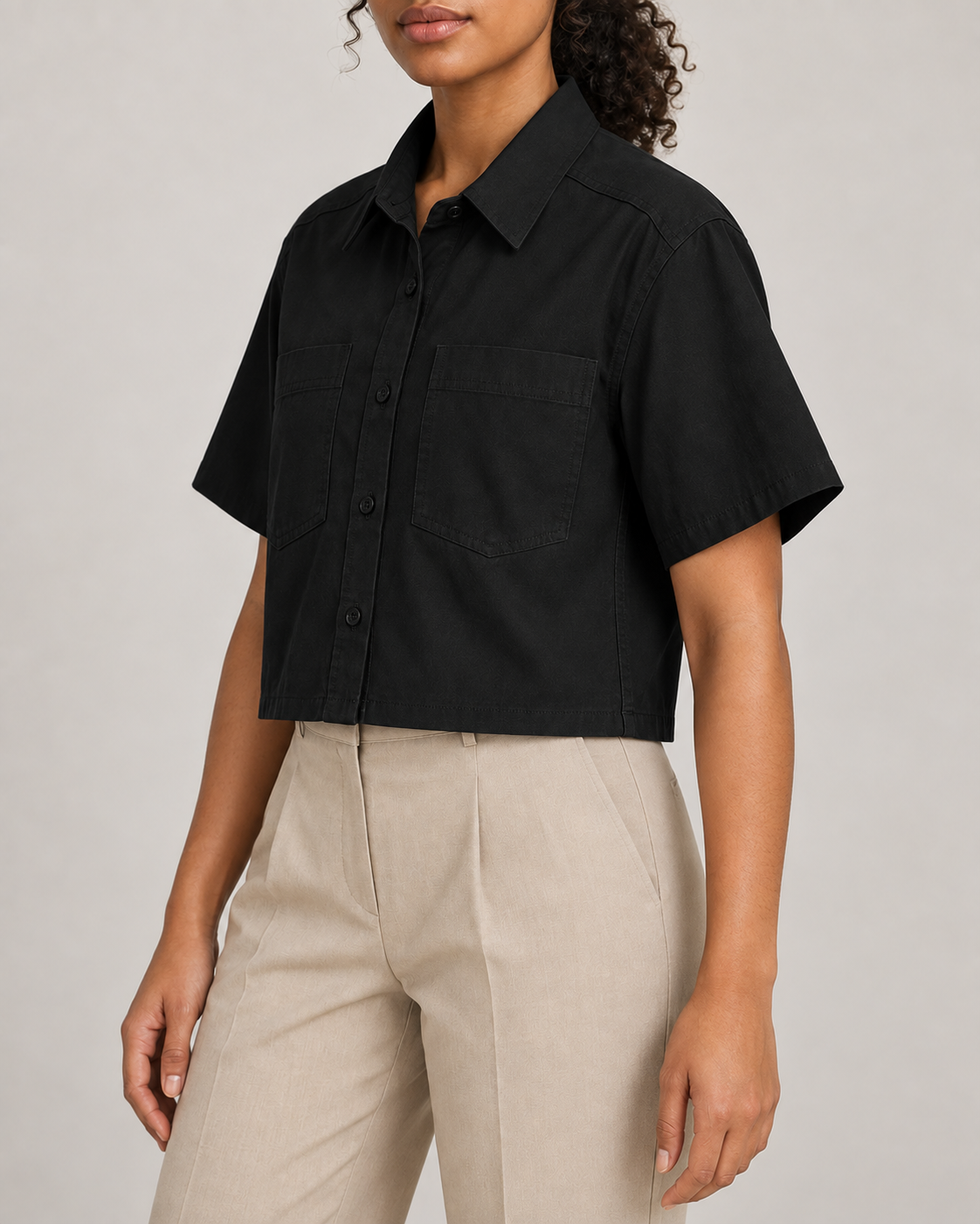 Three-quarter side view of Quiet Line Crop Shirt in Black, showing short sleeves and the boxy cropped silhouette.