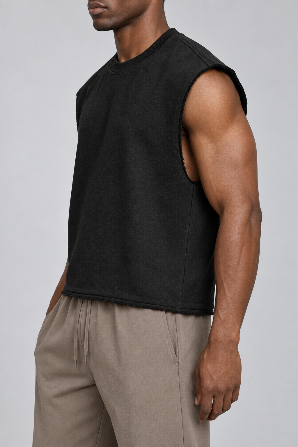 Side view of Raw Form Terry Tank in Black, showing the wide arm opening and short boxy silhouette.