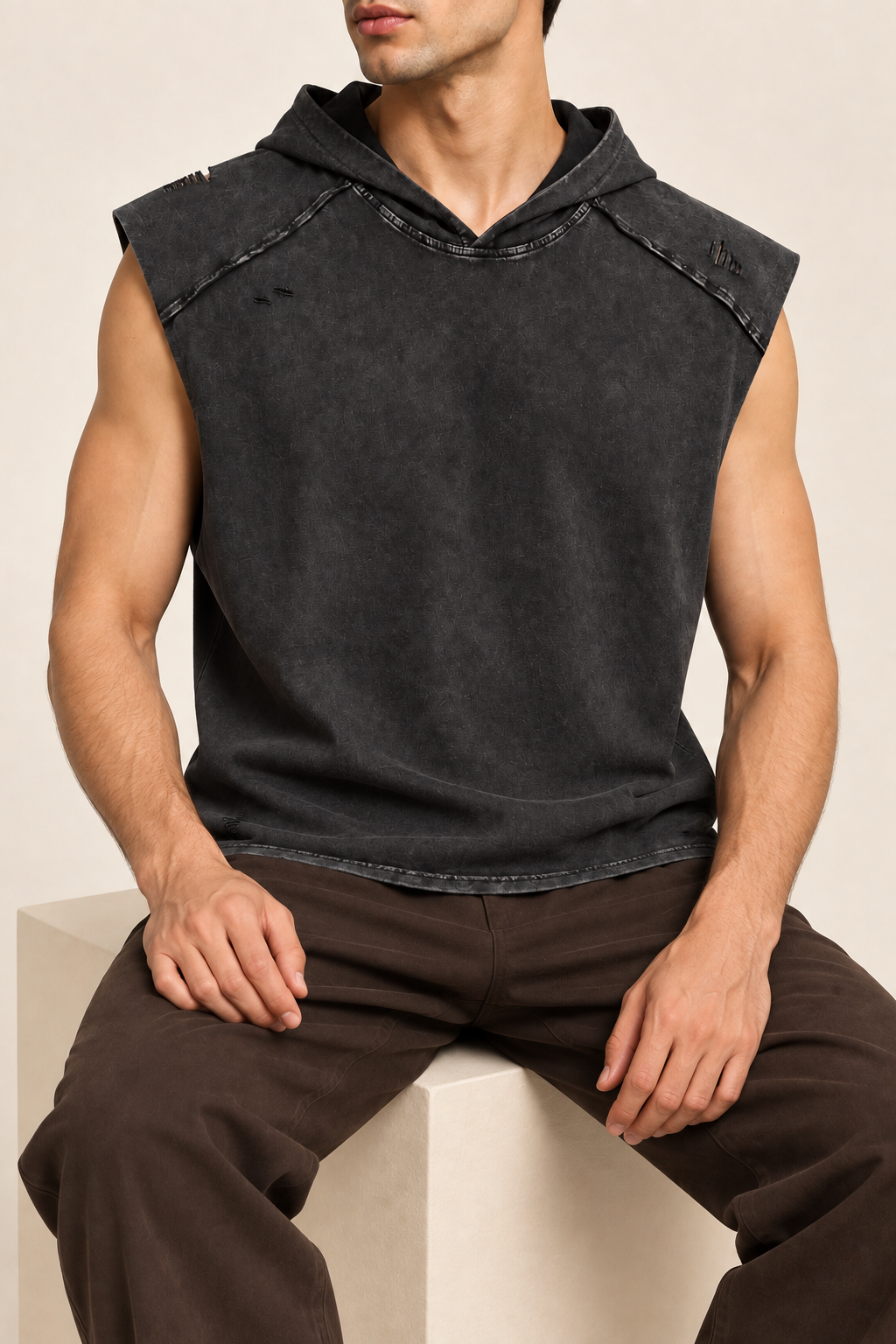 Seated view of Soft Static Hooded Tank in Black, showing the loose drape and unprinted washed fabric.