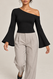 Quiet Arc Bell Sleeve Top in Black. Walking pose showing the flared sleeves and cropped shape.