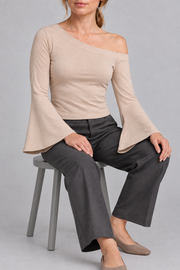 Quiet Arc Bell Sleeve Top in Pale Khaki. Seated view showing the drape of both bell sleeves.
