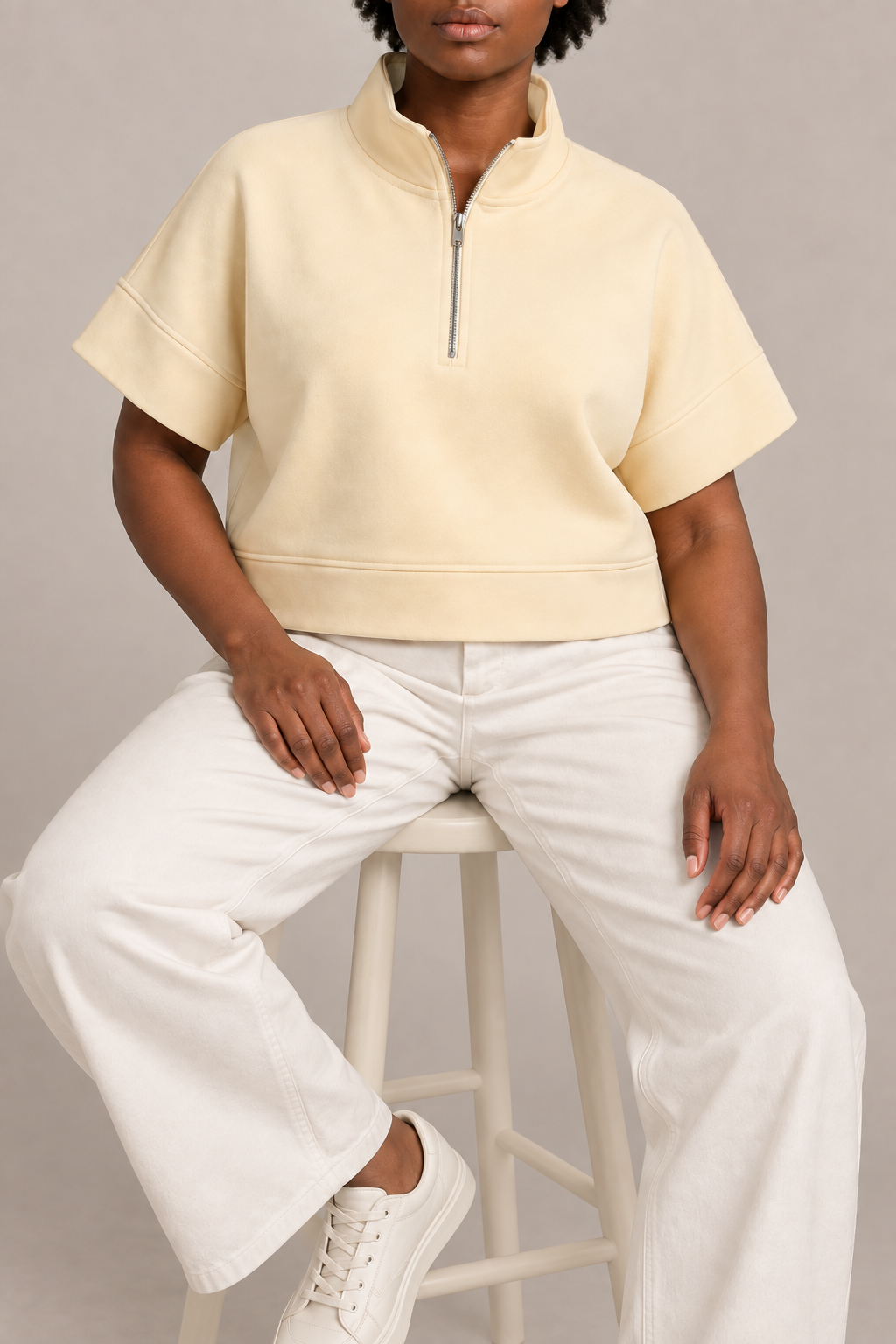 Soft Interval Zip Sweatshirt in Apricot. Seated view showing the relaxed shape and natural knit drape.