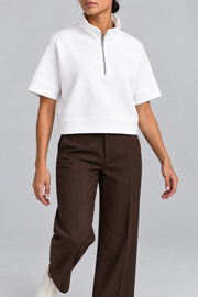 Soft Interval Zip Sweatshirt in White. Walking pose showing the loose cropped shape and short sleeves.