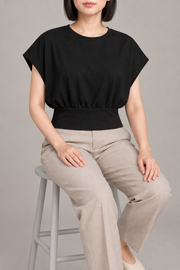 Soft Gather Dolman Top in Black. Seated view showing the soft drape and round neckline.
