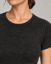 Neckline detail of Soft Trace Bodysuit in Washed Black, showing bound edging, fine vertical ribs and washed texture.