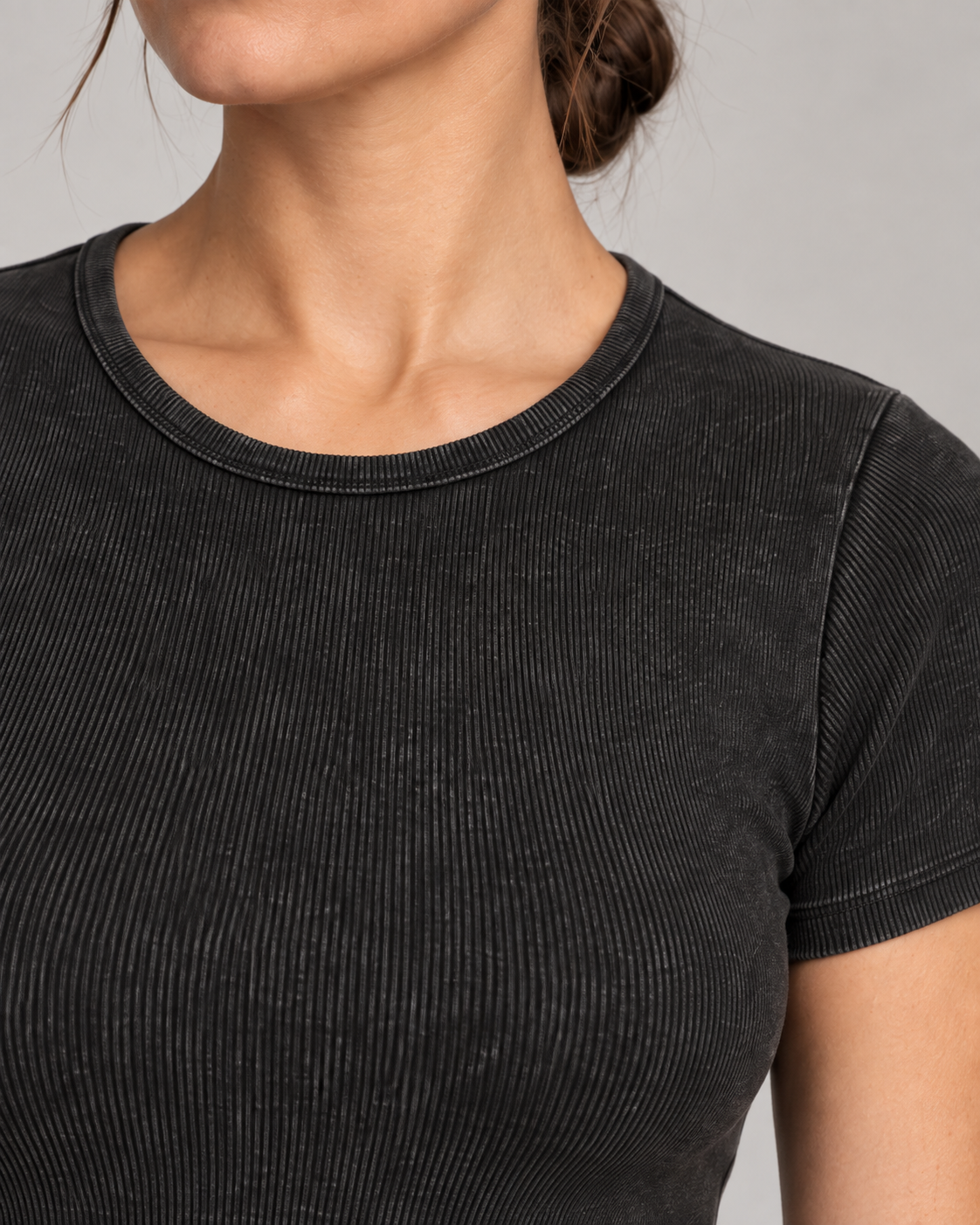 Neckline detail of Soft Trace Bodysuit in Washed Black, showing bound edging, fine vertical ribs and washed texture.