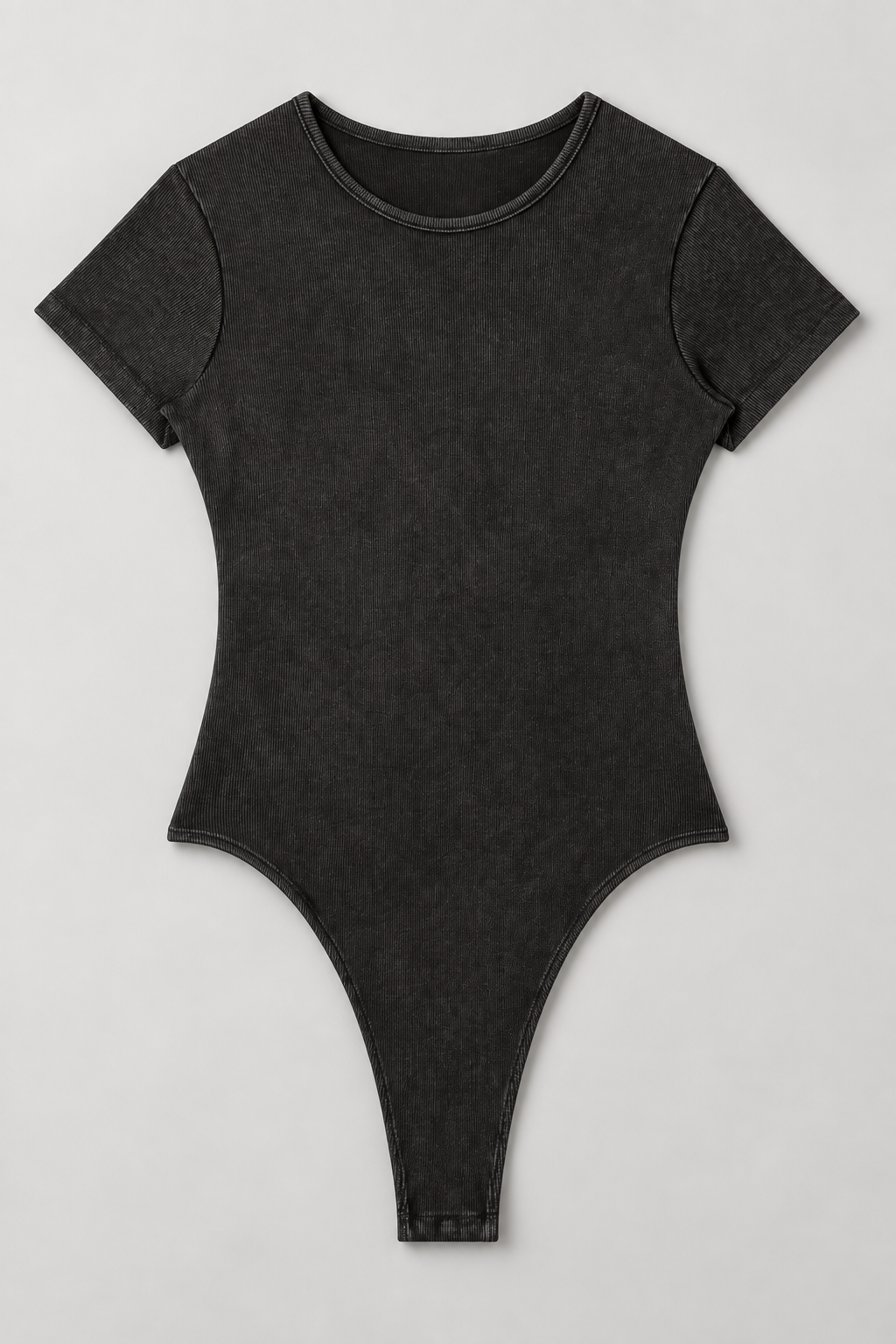 Full front flat-lay of Soft Trace Bodysuit in Washed Black, showing the plain ribbed one-piece shape and high-cut leg openings.