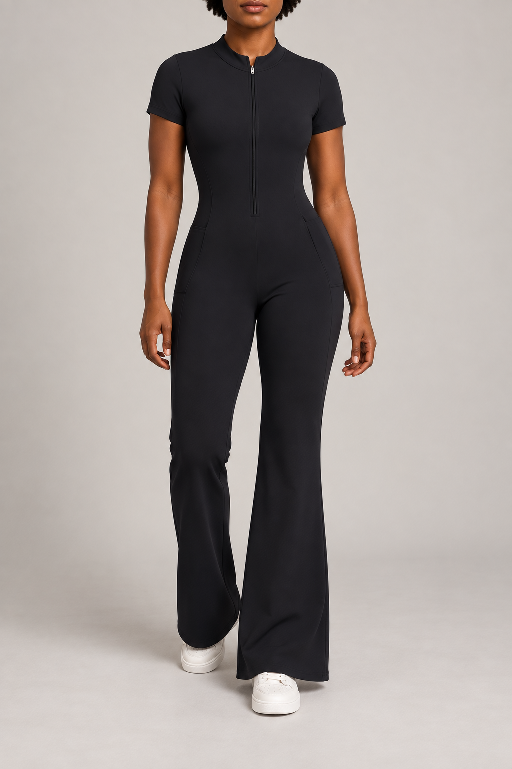 Contour Flare Zip Jumpsuit in Black. Front studio view showing the mock neckline, short front zip and flared legs.