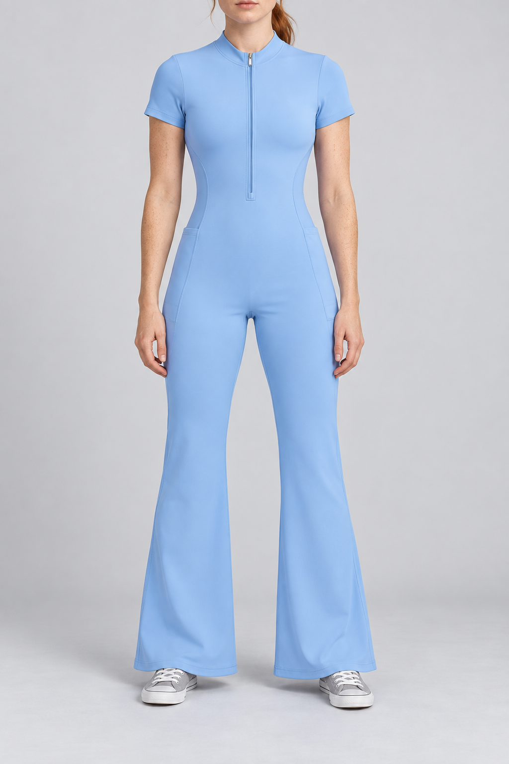 Contour Flare Zip Jumpsuit in Blue. Front studio view showing the short zip, mock neckline and full flared silhouette.