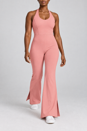 Open Line Halter Jumpsuit in Pink. Walking studio view showing the flared hems and small side openings in motion.