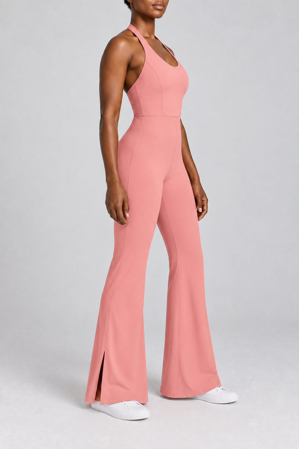 Open Line Halter Jumpsuit in Pink. Three-quarter side studio view showing the sleeveless shape and outer hem slit.