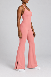Open Line Halter Jumpsuit in Pink. Three-quarter side studio view showing the sleeveless shape and outer hem slit.