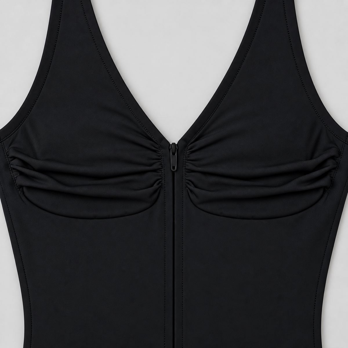 Soft Gather Zip Bodysuit in Black. Close-up studio view showing the gathered fabric, V-neck edging and black zipper.