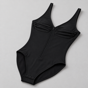 Soft Gather Zip Bodysuit in Black. Oblique studio view showing the one-piece shape, bound leg openings and snap fastening.