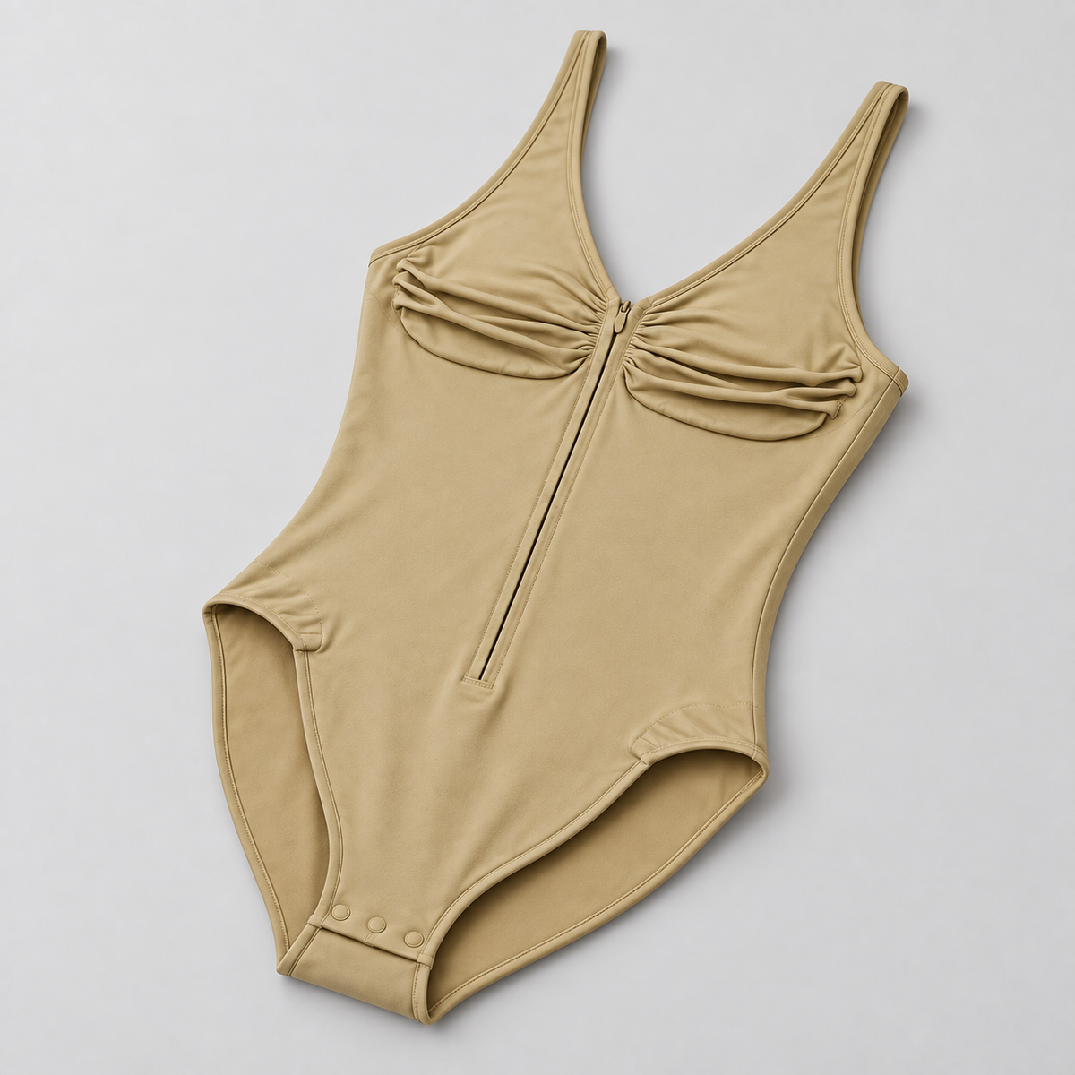 Soft Gather Zip Bodysuit in Khaki. Oblique studio view showing the one-piece shape, bound leg openings and snap fastening.