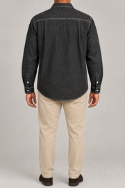 Rear view of Worn Line Denim Shirt in Black, showing the contrast-stitched back yoke, side pleats and curved hem.