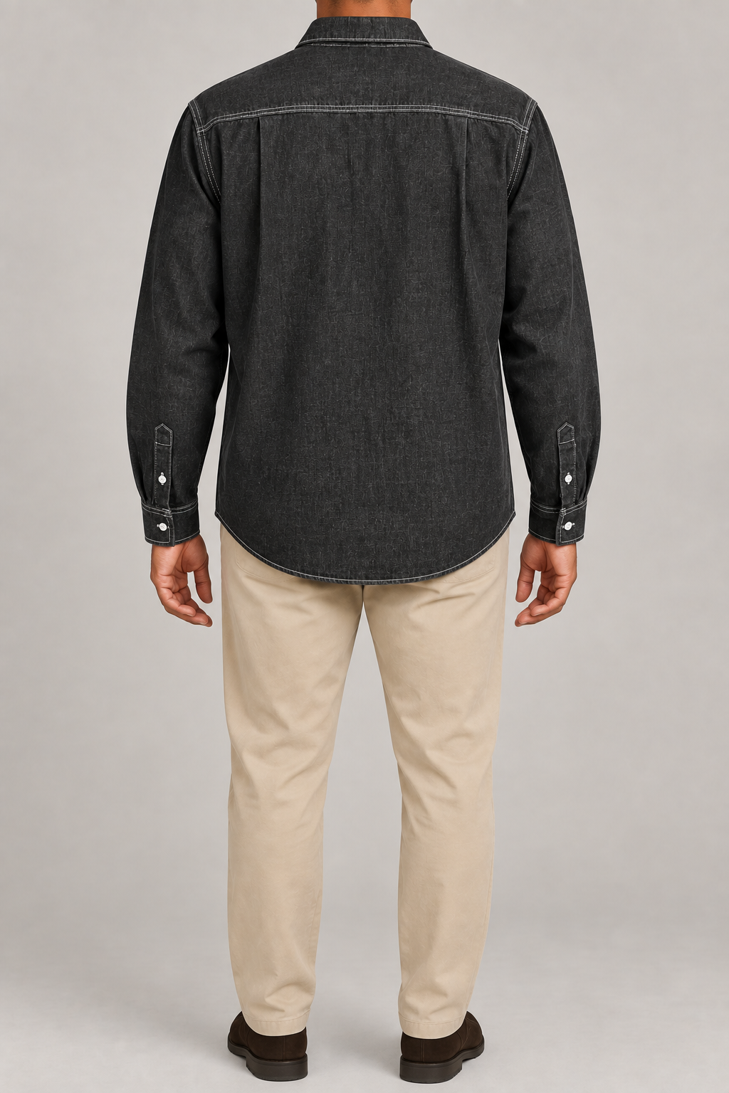 Rear view of Worn Line Denim Shirt in Black, showing the contrast-stitched back yoke, side pleats and curved hem.