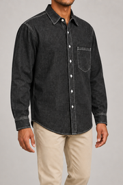 Three-quarter view of Worn Line Denim Shirt in Black, showing dropped shoulders, long sleeves and the curved plain hem.