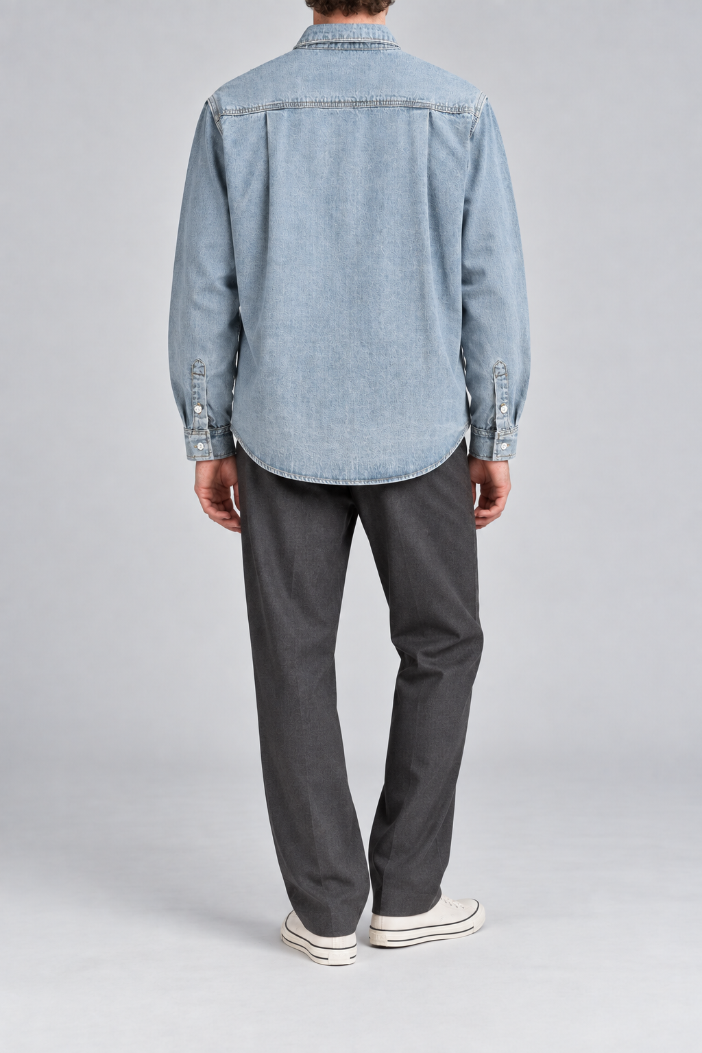 Rear studio view of Worn Line Denim Shirt in Blue, showing the back yoke, two side pleats and curved hem.