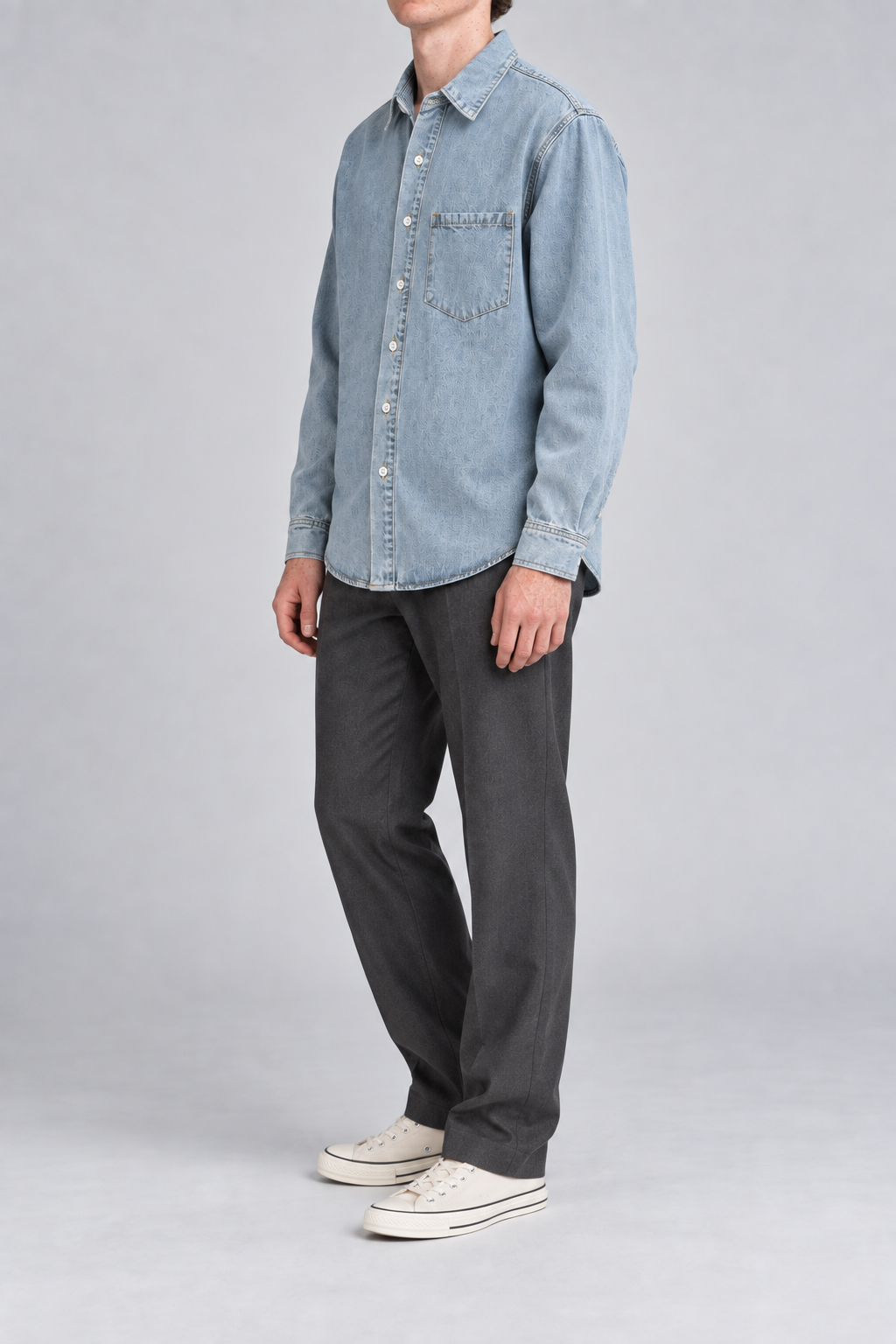 Side view of Worn Line Denim Shirt in Blue, showing the loose sleeves, curved hem and plain washed finish.