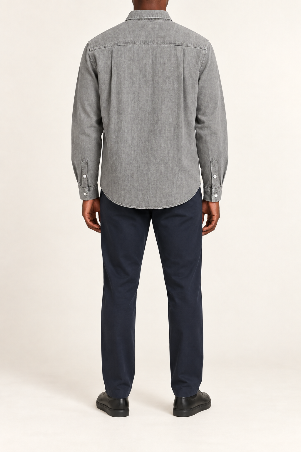 Rear view of Worn Line Denim Shirt in Light Gray, showing the stitched back yoke, side pleats and curved hem.
