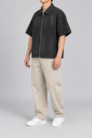 Three-quarter view of Quiet Shift Zip Denim Shirt in Black, showing the wide short sleeves and plain boxy silhouette.