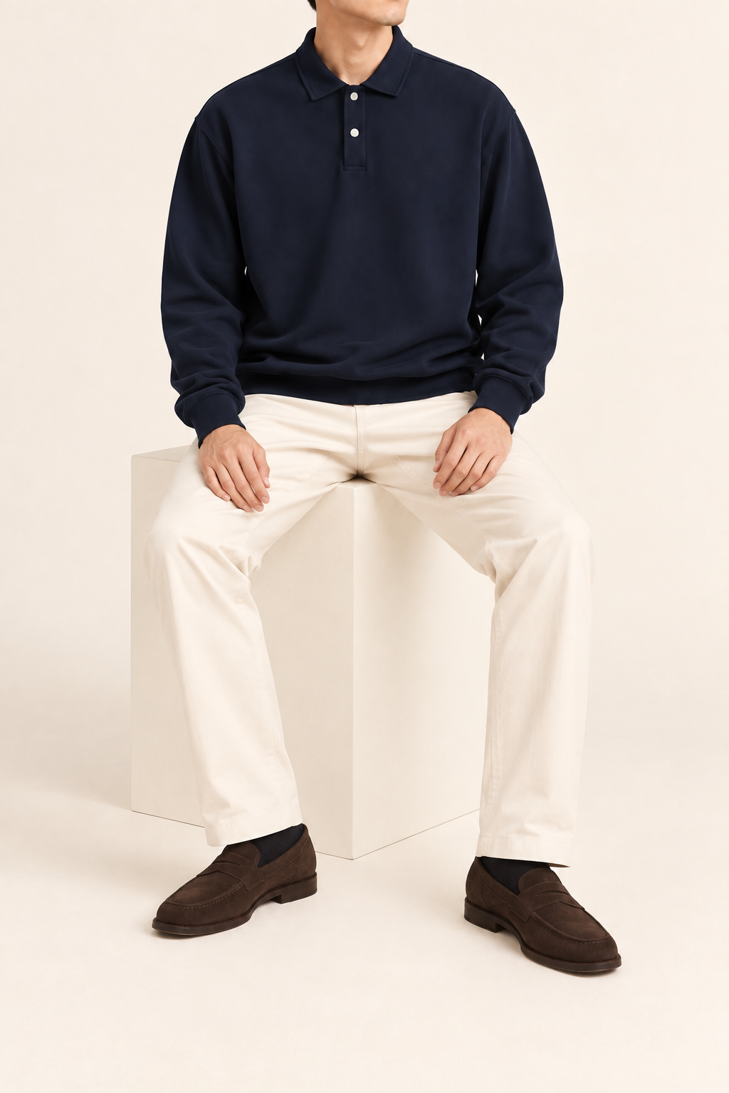 Quiet Club Polo Sweatshirt in Dark Blue. Seated view showing the loose fit and natural drape.
