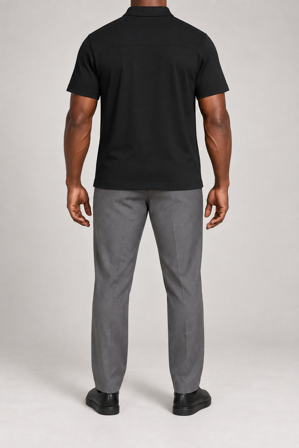 Clean Interval Zip Polo in Black. Rear view showing the upper back yoke seam and short sleeves.