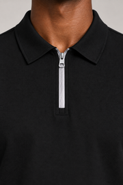 Clean Interval Zip Polo in Black. Close-up showing the pointed collar and pale silver-tone zipper.