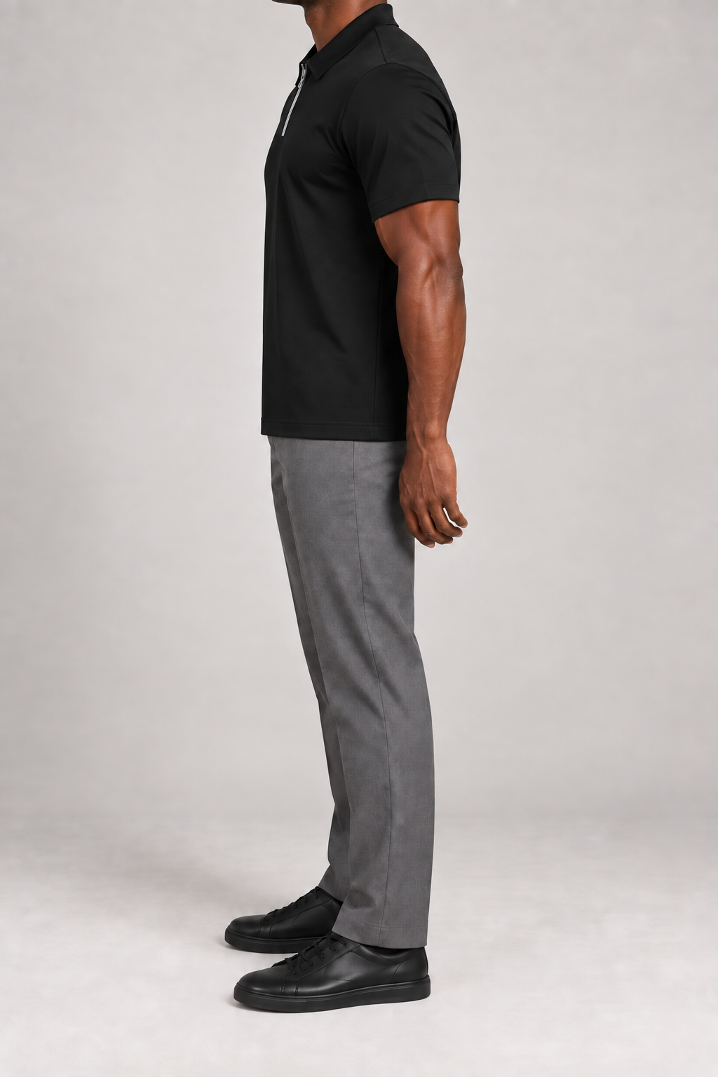 Clean Interval Zip Polo in Black. Side view showing the short sleeve and continuous straight hem.