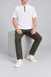 Clean Interval Zip Polo in White. Seated view showing the loose shape and smooth fabric drape.